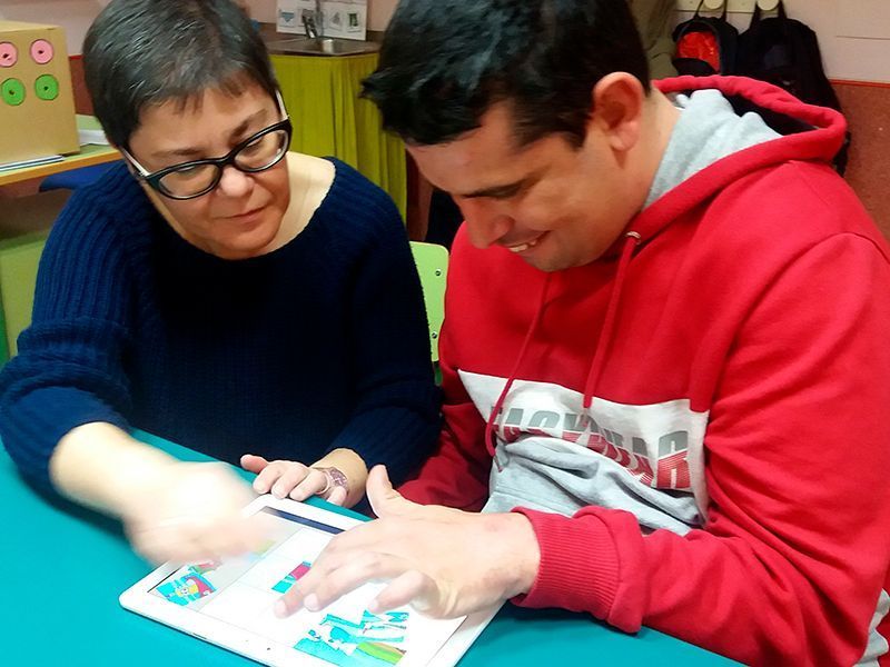 Chico_del_centro_de_dia_de_Astrapace_trabajando_con_la_tablet_junto_a_su_logopeda