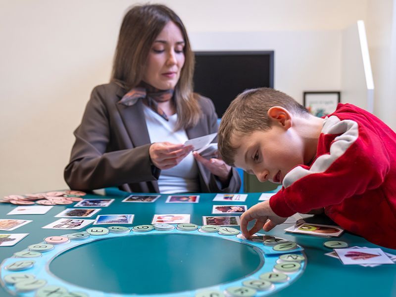 Niño_seleccionando_pictogramas_junto_a_su_logopeda