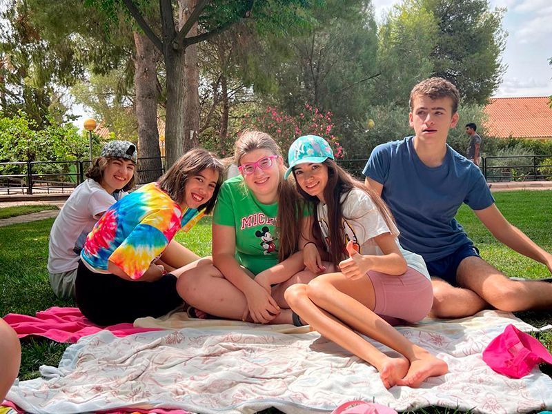 Chicos_de_astrapace_sobre_sus_toallas_en_el_cesped_de_la_piscina
